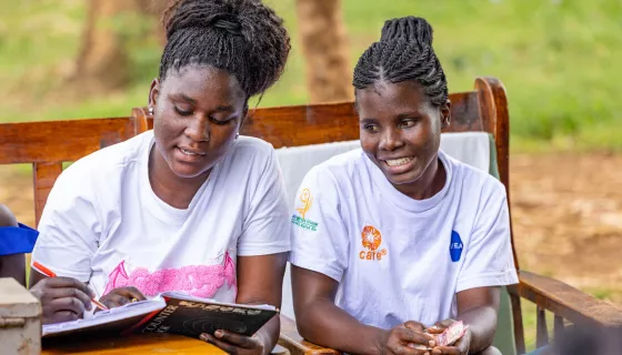 Two girls looking at notebook smiling