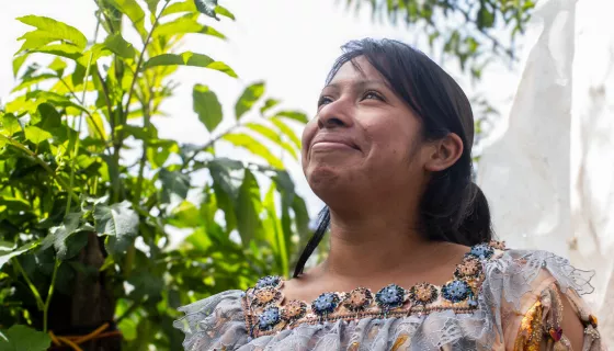 Portrait of woman with light smile chin up in a green outdoor space