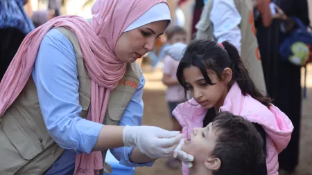 A health worker in Gaza administers a polio vaccination.